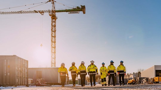 Työntekijät kävelevät aurinkoisessa säässä