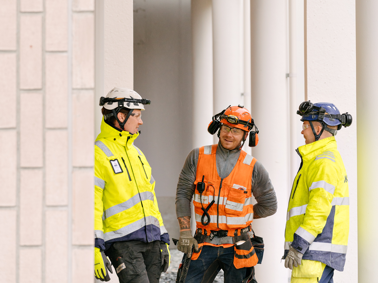 Skanskalaisia ja urakoitsijan työntekijä työmaalla