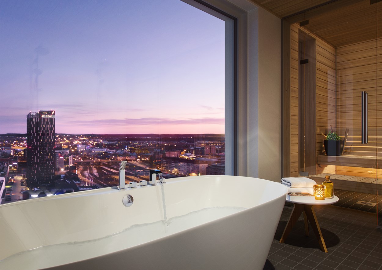 Iltainen kaupunkinäkymä Tampereen Luminaryn ylimmän kerroksen kylpyhuoneesta.