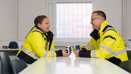 Skanskan työntekijät kahvitauolla pöydän ääressä