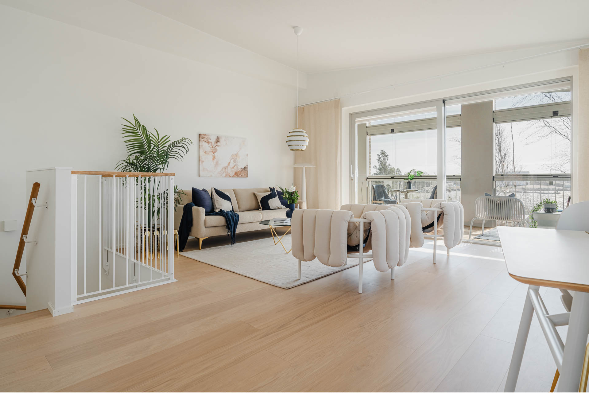 Kuva olohuoneesta, josta on portaat alakertaan.