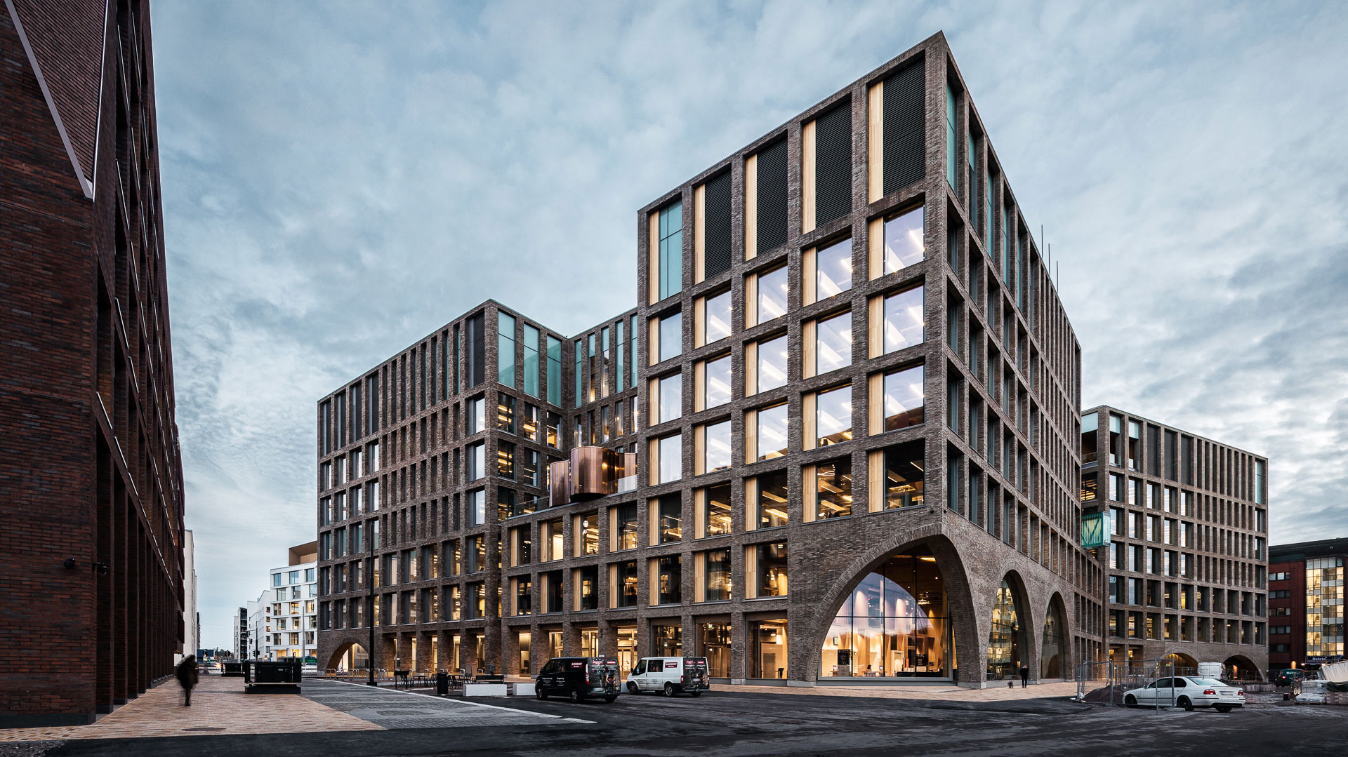 Kaupunkiympäristön toimitalo sulautuu Kalasataman rouheiden teollisten tiilirakennusten jatkumoon. Julkisivun moderneja kaarirakenteita ei voi olla huomaamatta. Seitsemänkerroksiseen rakennukseen onkin muurattu yli miljoona tiilenpäätä.