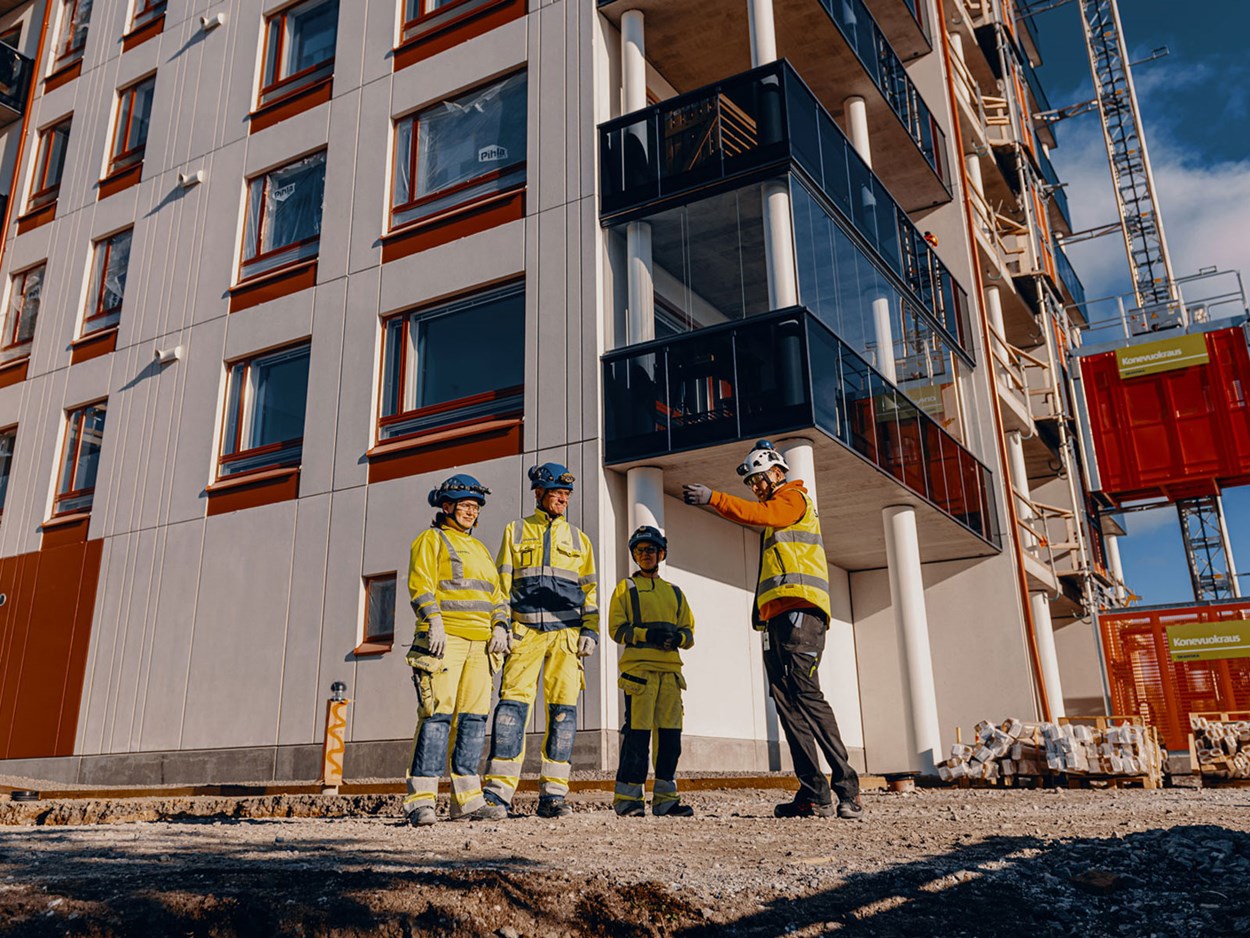 Työntekijöitä keskustelemassa työturvallisuudesta työmaalla.
