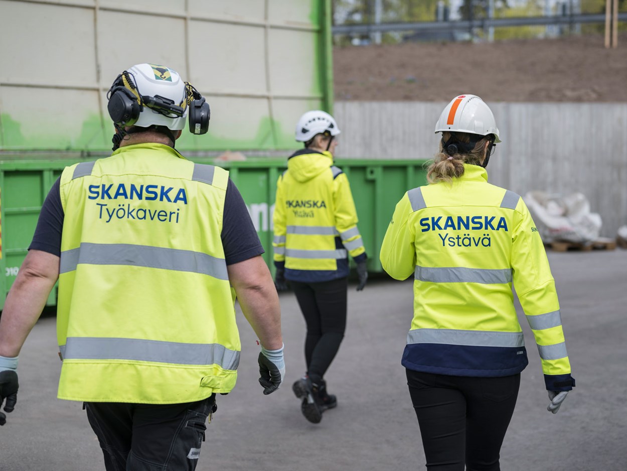 Työnjohtoa ja työntekijä kävelemässä työmaalla.
