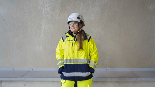 Skasnkalainen työmaalla betoniseinän edessä turvavarusteet yllä.