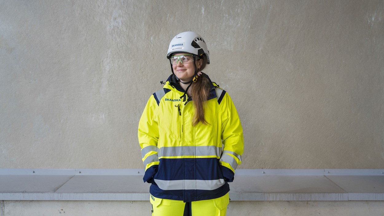 Skasnkalainen työmaalla betoniseinän edessä turvavarusteet yllä.